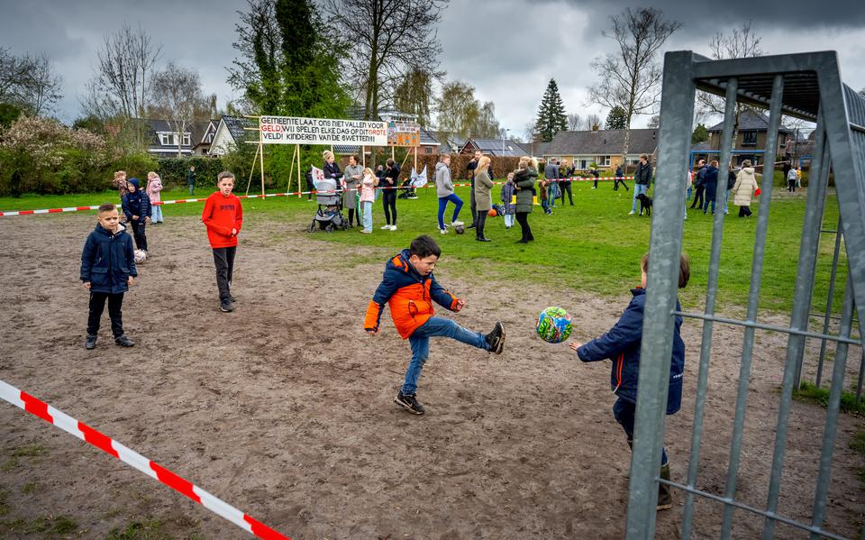 Kinderen spelen op het veld bij basisschool De Swetten, terwijl het protest gaande is. 