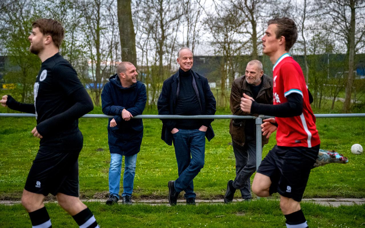 Voorzitter Jelle de Vries, diens vader Bonne de Vries (midden), samen met Harm Oosterbaan (rechts) samensteller van het jubileumboek bekijken de training van het eerste elftal van v.v. Oldeboorn.