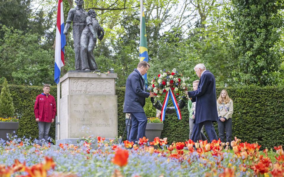 Burgemeester Johannes Kramer en kinderburgemeester Ruben van der Veen leggen een krans bij het monument aan de Noorderdwinger. 