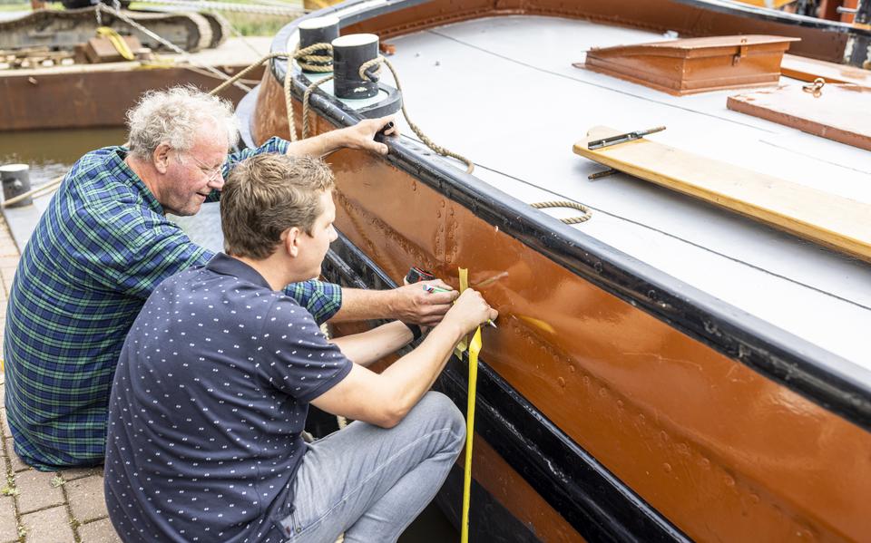 Walle en Ronald Hoekstra van de technische commissie van de IFKS controleren of De Bunsjoter precies op de denkbeeldige waterlijn ligt voor het aanbrengen van de ijkmerken. Daarmee kan worden gecontroleerd of het schip voldoet aan het minimale gewicht.