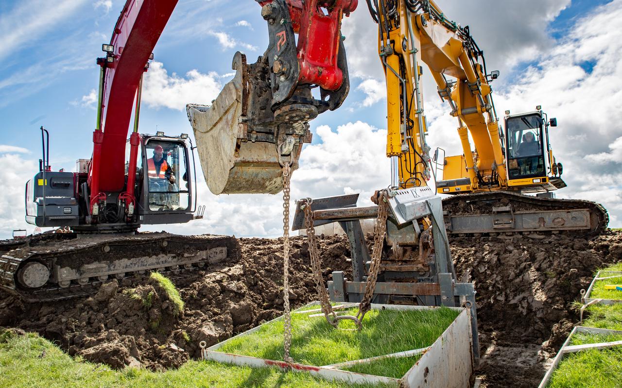 Een pakket klei van 10 ton wordt door kraanmachinisten Jan Rook en Sietse de Boer uit de dijk bij Blija getild. Een pakket klei van 10 ton wordt door kraanmachinisten Jan Rook en Sietse de Boer uit de dijk bij Blija getild.