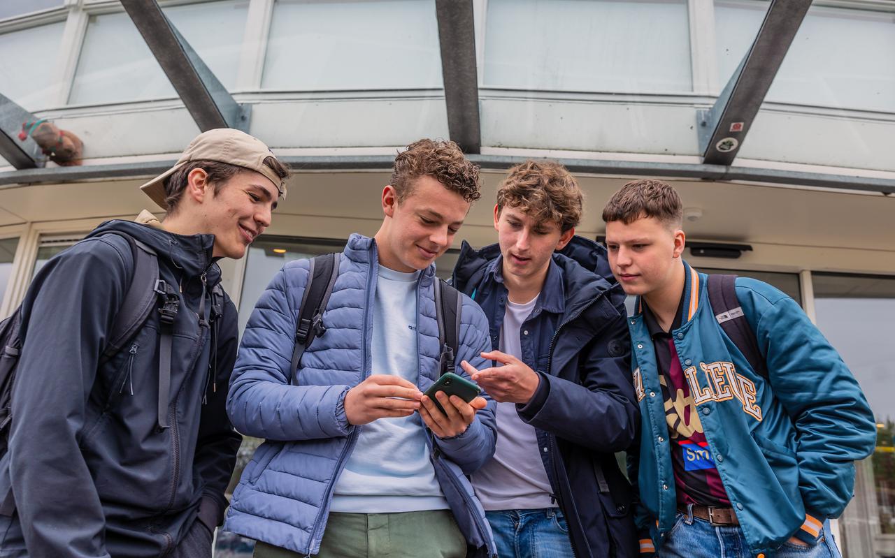 Jelke de Vries (19), Jurian Boorsma (17), Merijn Haak (17) en Thijs Boorsma (17) kijken buiten de Sneker Sporthal hoe laat de antwoorden van het vwo-examen Duits online komen.