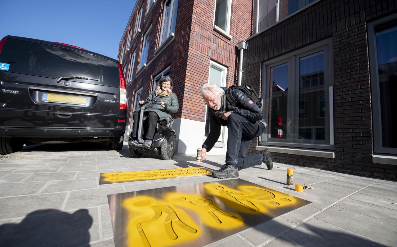 Pauline Everts bij de auto die de stoep op Achter de Hoven afsluit. Bindert Kloosterman spuit met een raster een tekst op het trottoir om mensen attent te maken op de toegankelijkheid. Pauline Everts bij de auto die de stoep op Achter de Hoven afsluit. Bindert Kloosterman spuit met een raster een tekst op het trottoir om mensen attent te maken op de toegankelijkheid.