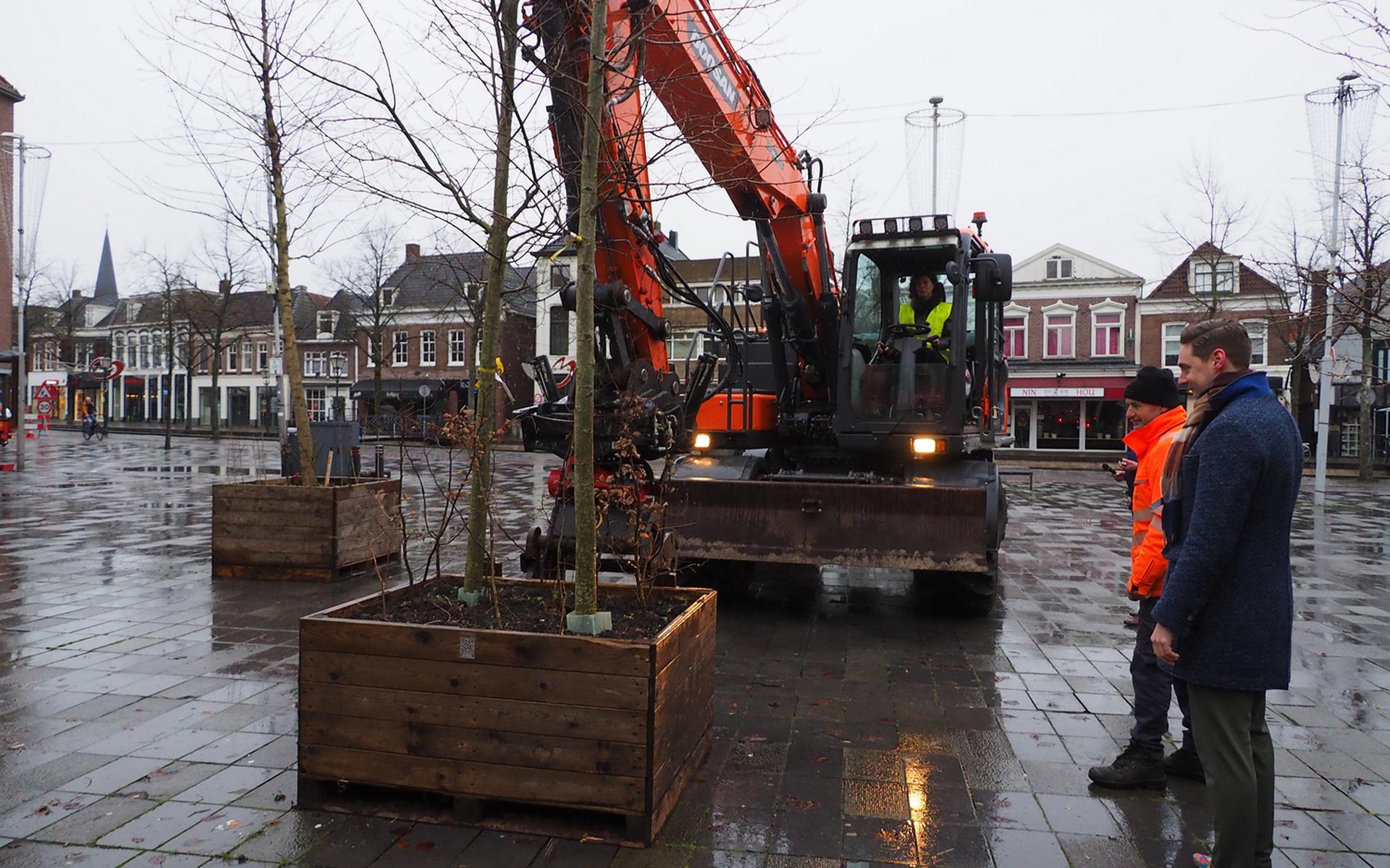 Met behulp van een kraan plaatste wethouder Sybrig Sijtsma de eerste boom op het Gemeenteplein. Rechts initiatiefnemer Geert Dijkstra.        