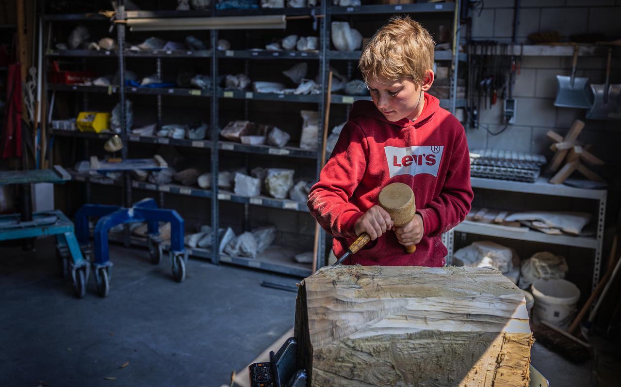 Ave Kramer (9) aan het beeldhouwen met hout bij zijn oudoom Jehannes Hibma. Foto: Niels de Vries