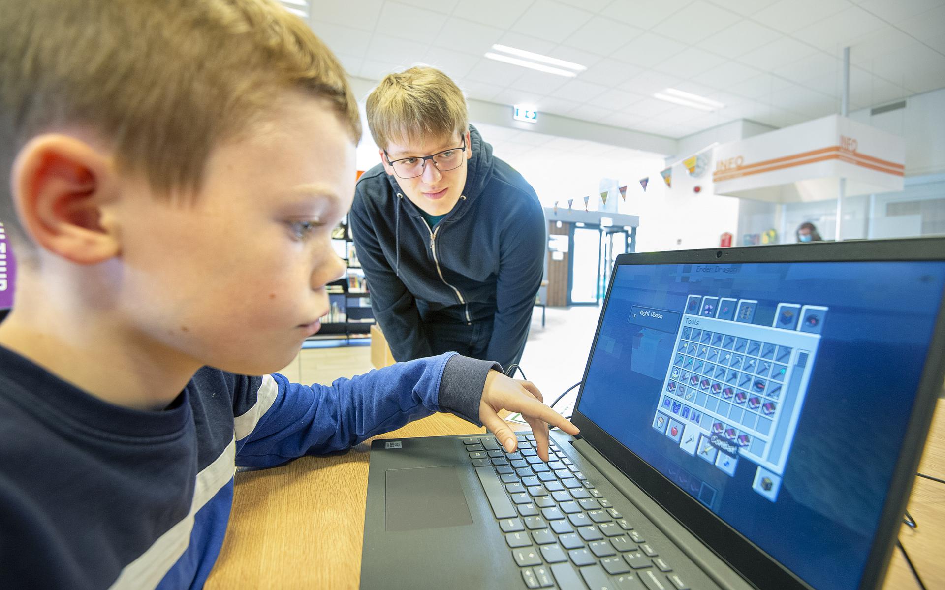 Jort van der Meulen geeft een workshop Minecraft in de bibliotheek in De Westereen. Hidde Bouma is aandachtig aan het spelen. 
