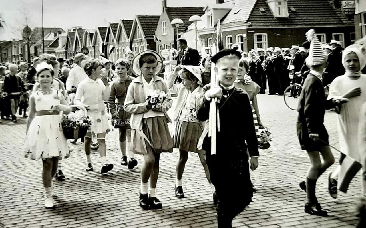 Koninginnedag 1962, leerlingen van de Juliana van Stolbergschool in optocht door de Stationsweg in Drachten.