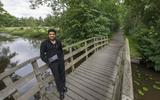 Sammy Shefa Idris op een bruggetje nabij zijn ouderlijk huis in Hurdegaryp, waar hij altijd het gevoel van thuiskomen krijgt.
