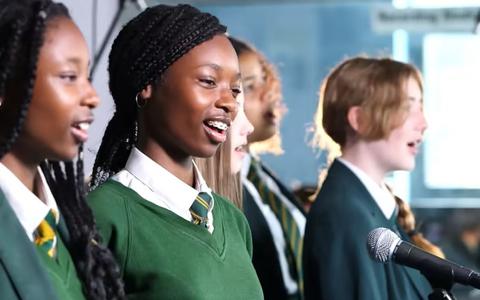 Leerlingen van een school in Manchester zingen New Order's Ceremony voor het goede doel. 