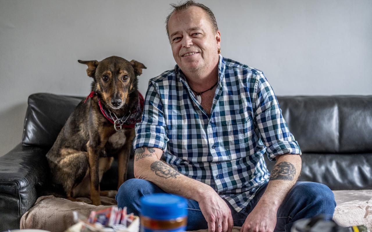Peter van Gorkom (52) zit samen met zijn hond Wolf op de bank in zijn woning. ,,Ik ben altijd bang om mijn huis kwijt te raken."