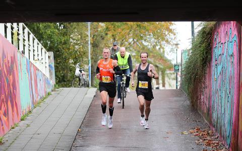 Erwin de Vries (links) en Willem de Boer aan kop in de halve marathon van Loop Leeuwarden. Hier lopen ze na 18,5 kilometer in de fietstunnel onder de Dammelaan.