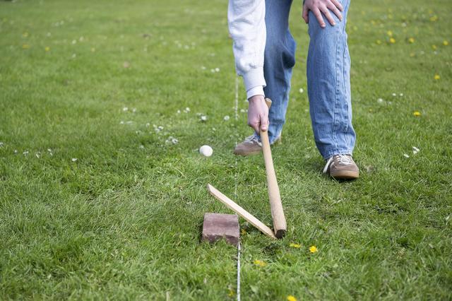 De kooi wordt omhoog getikt, vervolgens moet ie zo ver mogelijk weg worden geslagen.