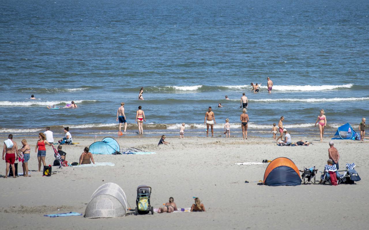 Badgasten genieten van het mooie weer op het strand bij Nes op Ameland.  Warme dagen zullen in de toekomst waarschijnlijk veel vaker voorkomen.