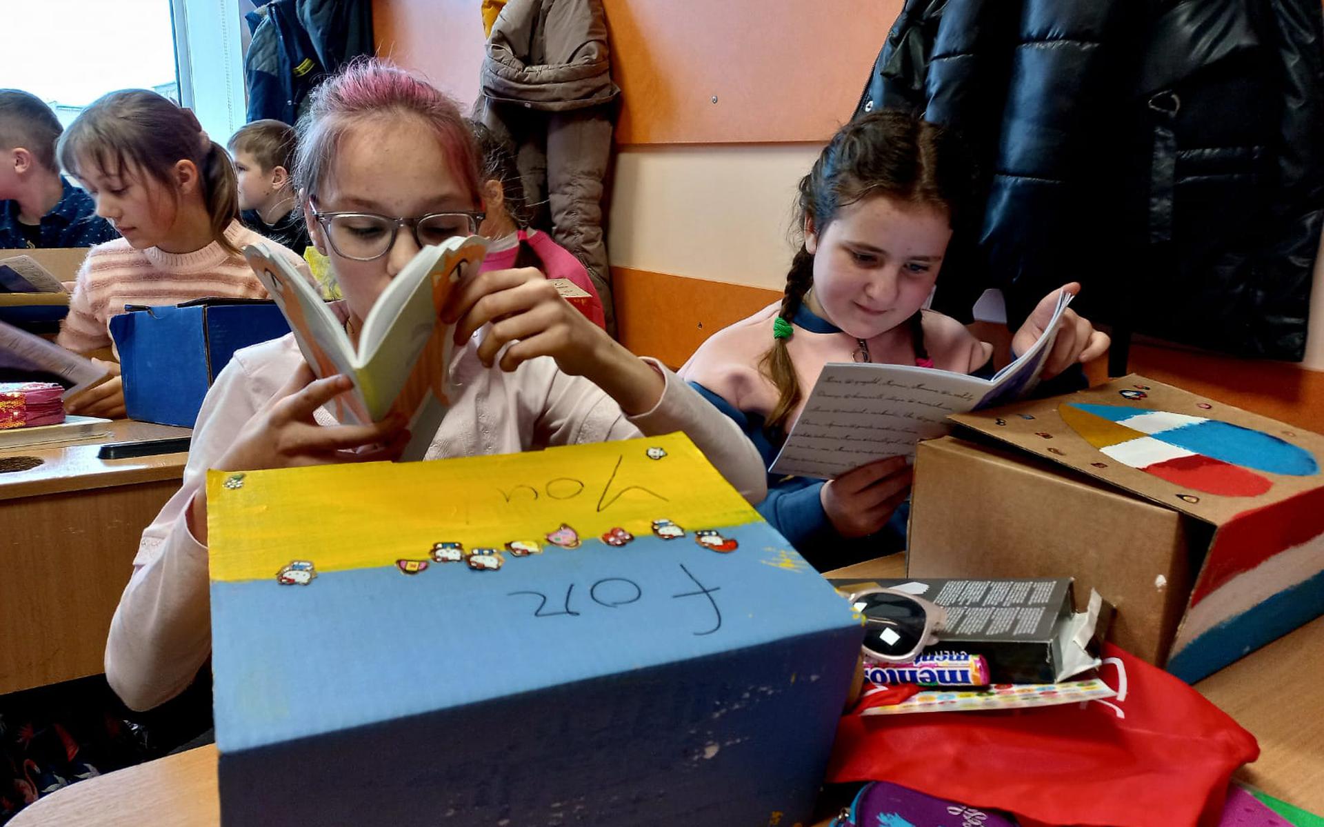In hun provisorische klaslokaal bekijken kinderen uit Dmitrivka hun cadeaus uit Grou.