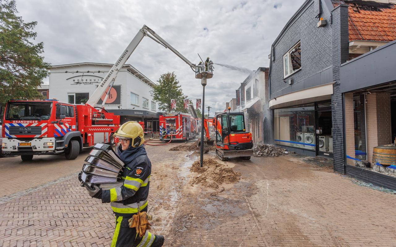 Een brandweerman stelt de administratie van Hofstra Witgoed veilig na de brand van 7 op 8 augustus in Snack Plaza in Wolvega. Twee panden raakten verwoest, Kamstra Schoenen liep aanzienlijke rook- en waterschade op. Niemand raakte gewond. Een brandweerman stelt de administratie van Hofstra Witgoed veilig na de brand van 7 op 8 augustus in Snack Plaza in Wolvega. Twee panden raakten verwoest, Kamstra Schoenen liep aanzienlijke rook- en waterschade op. Niemand raakte gewond.