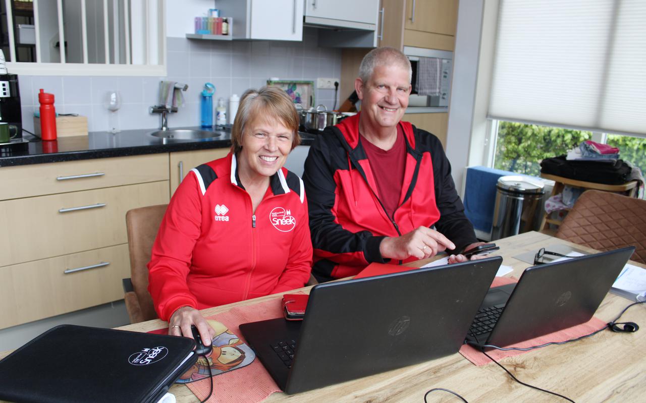 Tjitske Wind en Klaas de Groot in karakteristieke pose aan de keukentafel met elk hun eigen laptop en telefoon waarmee ze veel zaken regelen voor de volleybalclub.