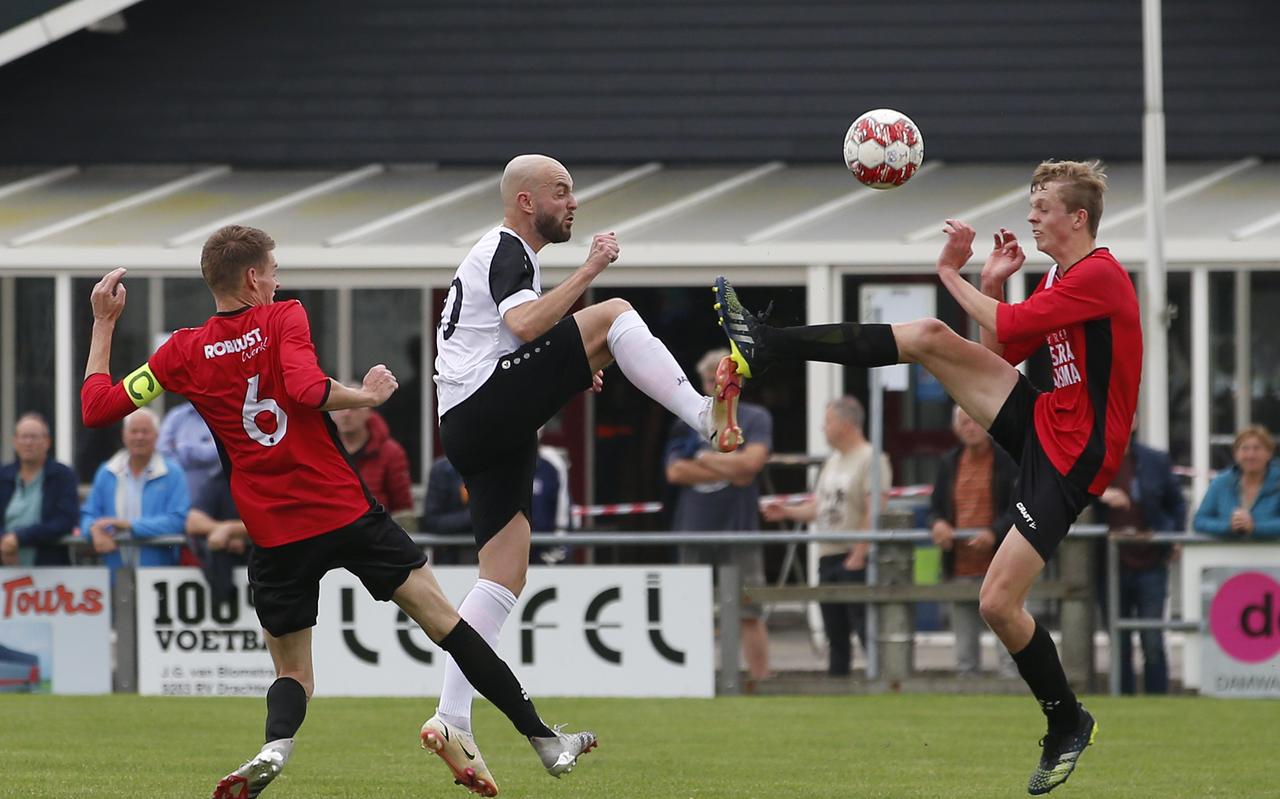 Sicco Bouwer (m) is verwoed in een verhit duel om de bal met Broekster Boys-spelers Riemer Doornbos (l) en Klaas van der Meulen. Sicco Bouwer (m) is verwoed in een verhit duel om de bal met Broekster Boys-spelers Riemer Doornbos (l) en Klaas van der Meulen.