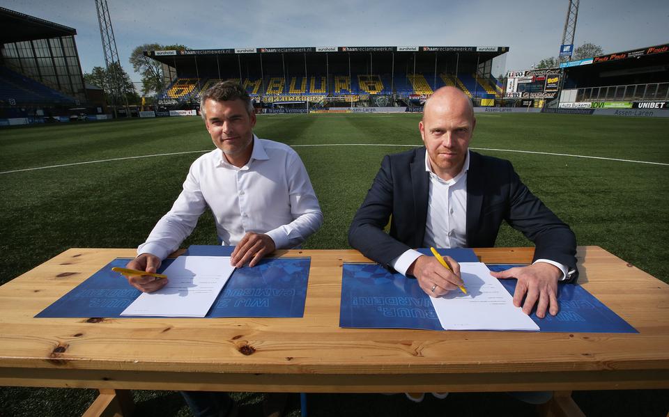 Folkert Leijten van Leyten Vastgoed en wethouder Hein de Haan tekenen de overeenkomst voor de herontwikkeling van het stadiongebied in Leeuwarden. Dit doen ze op de middenstip van het Cambuurstadion. 