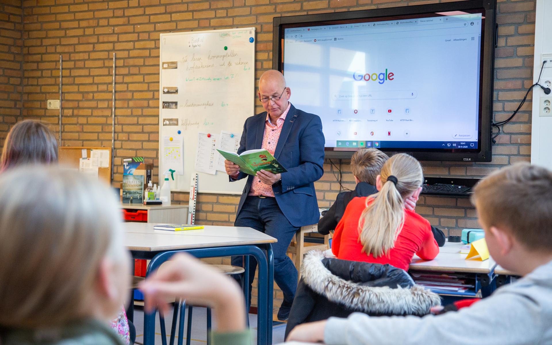 Wethouder Max de Haan van Achtkarspelen leest voor uit een Fries kinderboek, bij het begin van de kinderboekenweek