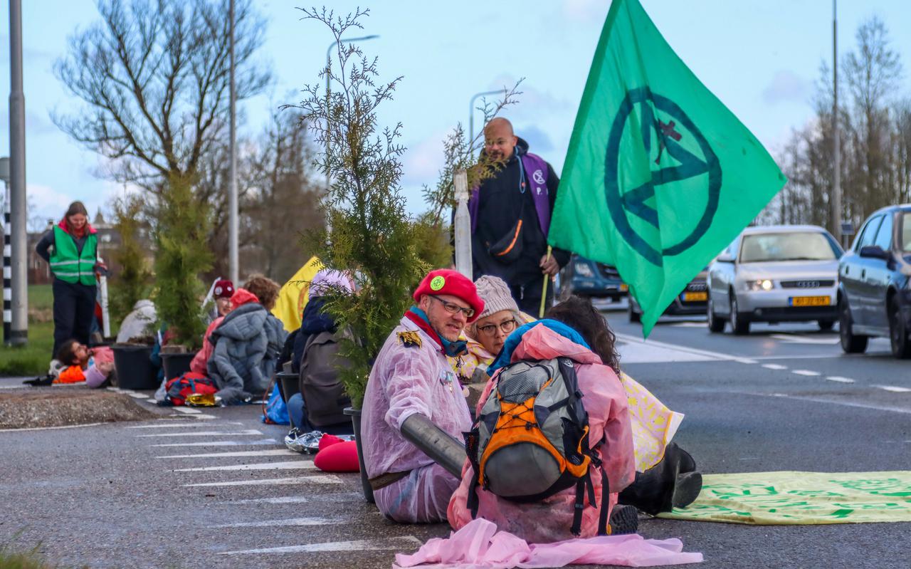 Demonstranten van Extinction Rebellion blokkeerden vorig jaar in april de ingang van Vliegbasis Leeuwarden. Ze zaten op de weg vastgeketend aan bomen. Op één incident met een automobilist na verliep het protest gemoedelijk.