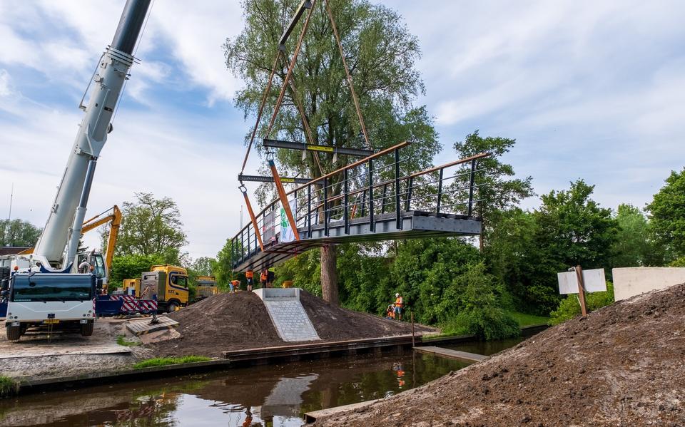 De fietsbrug wordt op zijn plek gehesen.