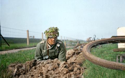 De Duitse Oberleutnant Fritz Naujoks, commandant van de derde Radfahrerabteilung, zoekt dekking in een talud bij de Afsluitdijk bij Kornwerderzand, mei 1940. Hij heeft zijn fiets vlak voor zich neergelegd.