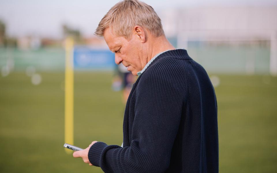 Technisch manager Foeke Booy kijkt op zijn telefoon tijdens het trainingskamp van SC Cambuur in San Pedro del Pinatar.