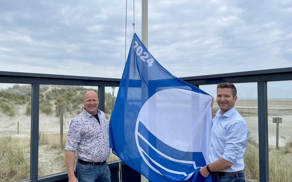 Wethouder Theo Faber en Fabian Kock hijsen blauwe vlag.