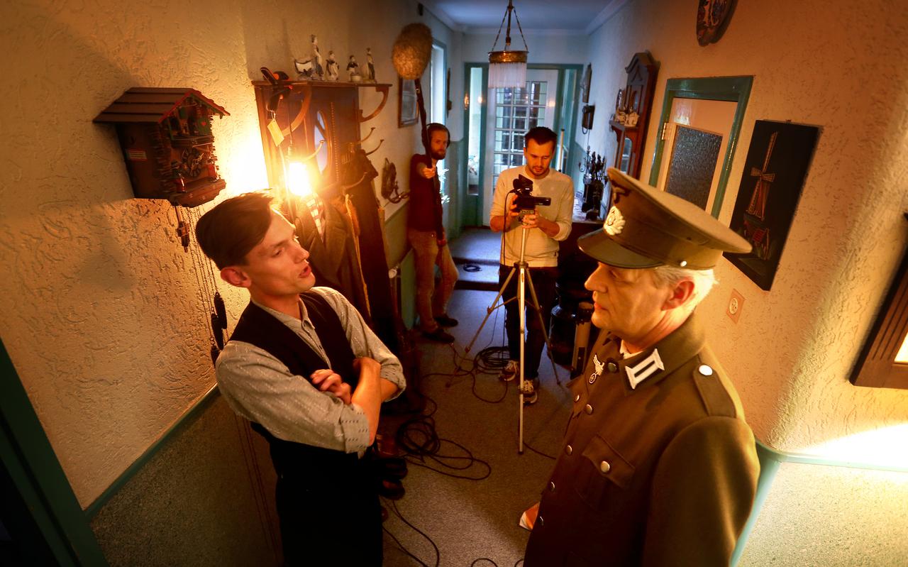 Filmopnames van 'De kraak van de kluis' in de lange gang van museumboerderij Ald Barrahûs in Wirdum. Links Romke Gabe Draaijer die de verzetsstrijder Lolle Rondaan speelt. 
