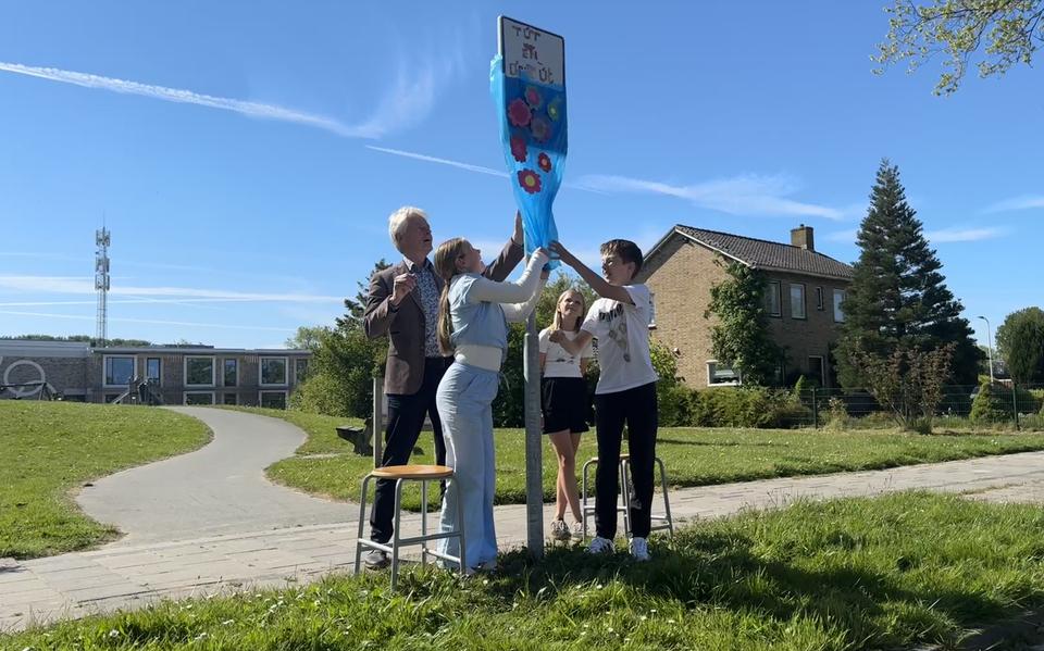 Wethouder Kees Arendz, groep 7-er Hanna Hallema en kinderburgemeester Thijmen de Vries, onthullen het nieuwe verkeersbord 'Tút en derút'.