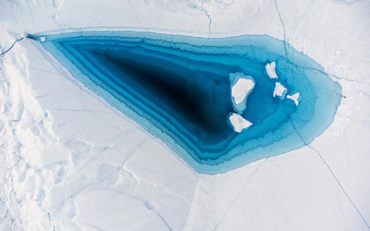 Een smeltgat, opgevuld met water, in een ijsberg in het westen van Groenland. 