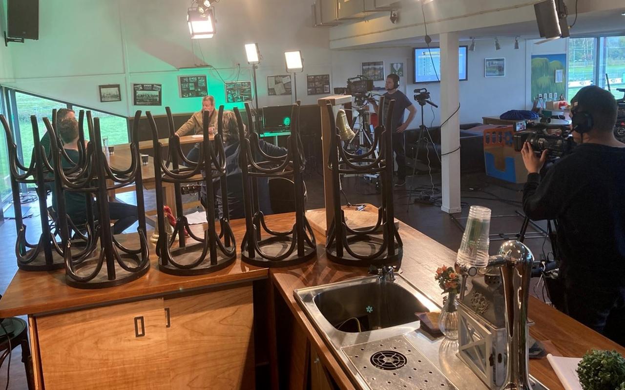 Kijkje tijdens de opnames van De lege kantine in het clubhuis van GAVC. Gezeten onder de witte lamp interviewt Walter Miedema zijn tafelgasten. FOTO LC Kijkje tijdens de opnames van De lege kantine in het clubhuis van GAVC. Gezeten onder de witte lamp interviewt Walter Miedema zijn tafelgasten. FOTO LC