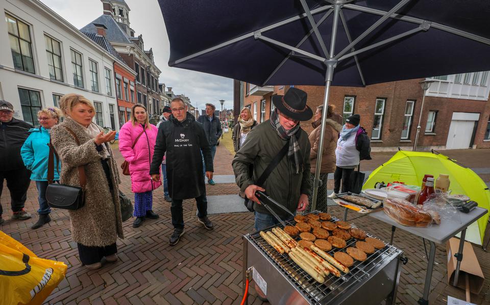 De geur van worstjes en hamburgers komt burgemeester Jannewietske de Vries tegemoet voorafgaand aan de gemeenteraad. Rechts naast haar met keukenschort actievoerder Francis van de Laar. 
