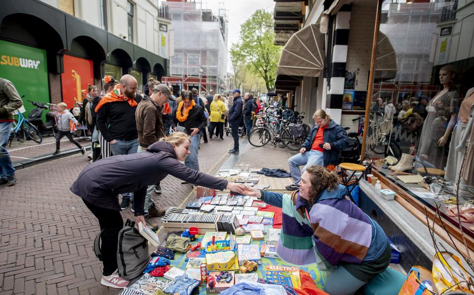 Sanne Alkema doet een transactie aan de Sint Jacobsstraat op Koningsdag 2024.