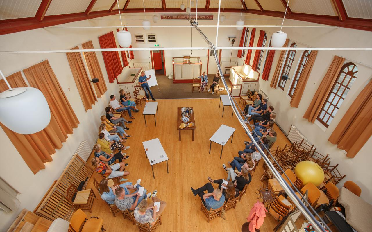 Belangstellenden horen in de voormalige Baptistenkerk in Haulerwijk de plannen aan voor de oprichting van een particuliere basisschool. Evert Jan Meeuwissen spreekt de zaal toe.