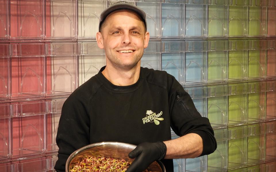 Hussain Salama, de eigenaar van dessertwinkel On Adore Pistachio in Leeuwarden, met een kom vol pistaches.