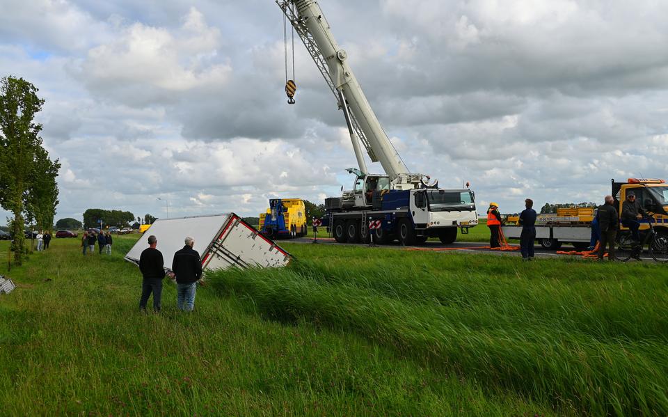Een hijskraan moet een vrachtwagen uit de sloot takelen bij Berltsum.