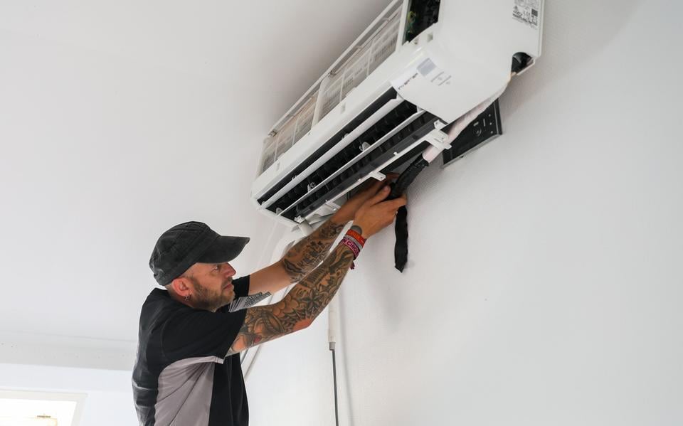 Sytse van der Meer (39) maakt de laatste kabels en buizen aan de airco vast.