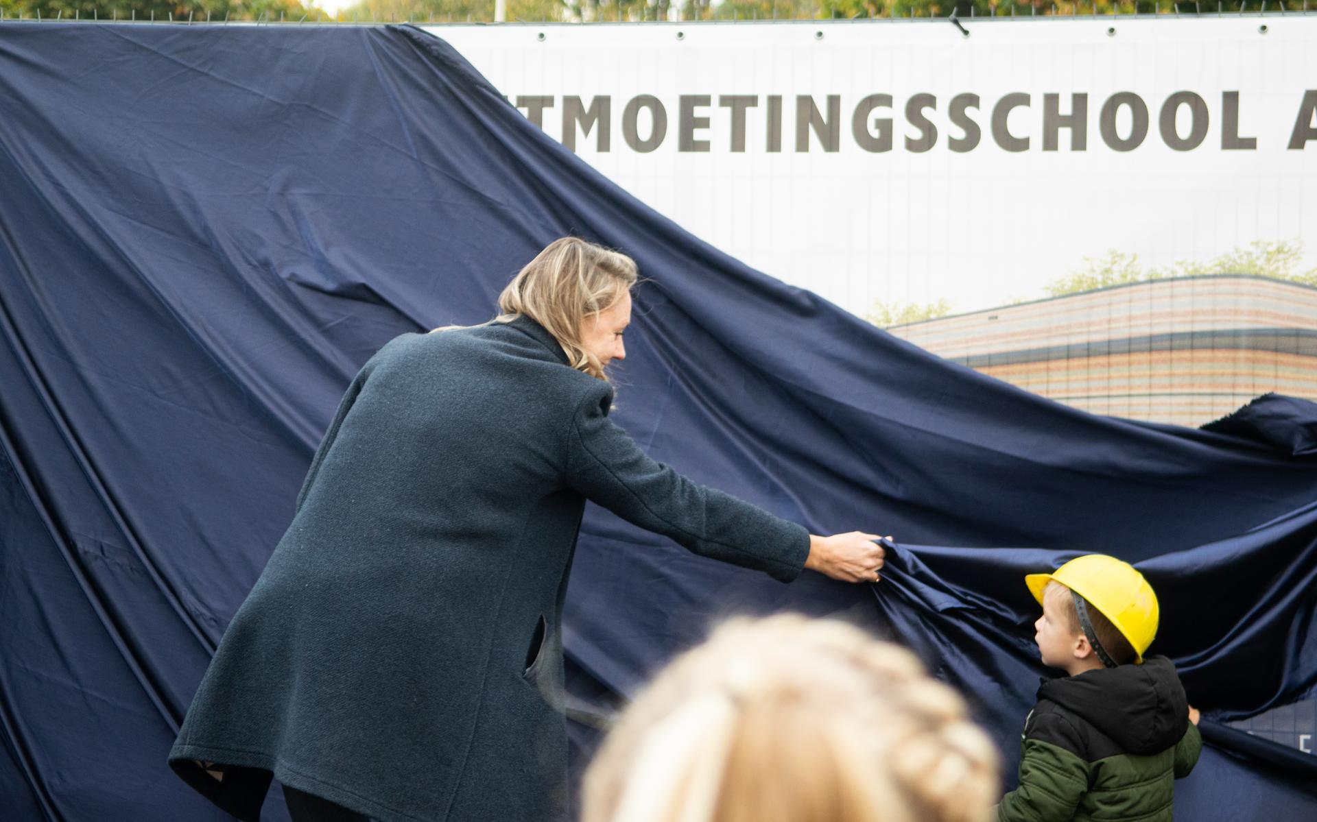 Wethouder Petra van den Akker onthult het bouwbord.