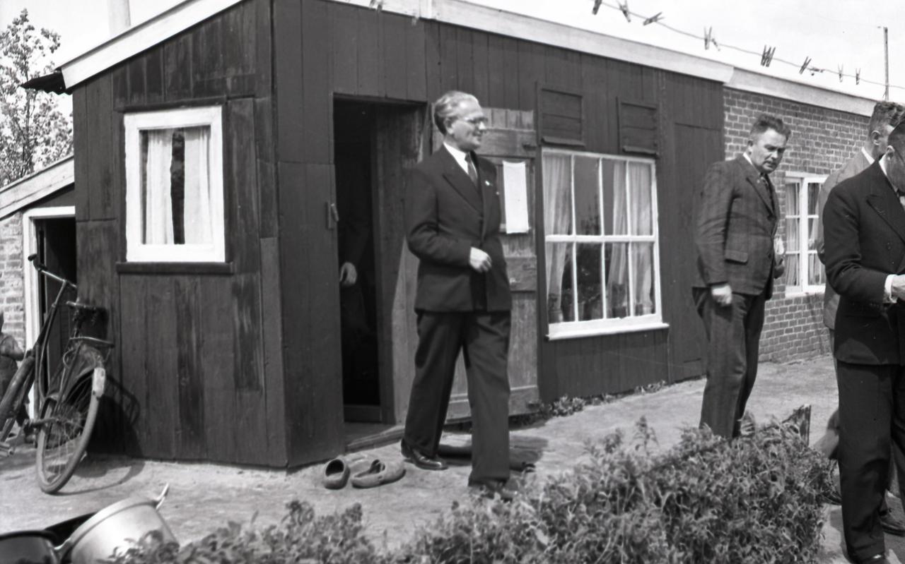 Minister In 't Veld bij Friese kippenhokken die werden bewoond door gezinnen. Hij maakte in 1949 een tour langs zulke overbevolkte minihuisjes. 