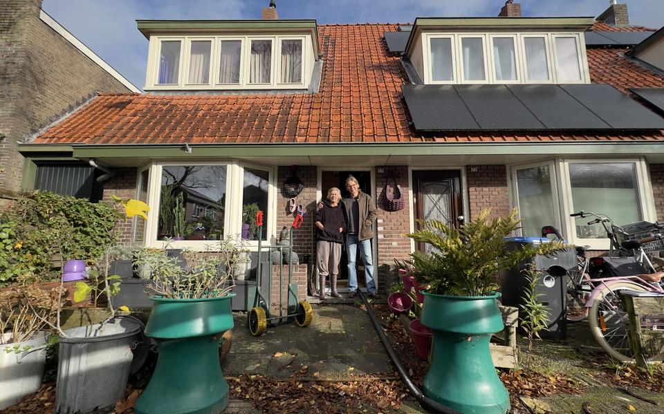 Corrie de Graaf en buurman Albert Mos voor de woning van De Graaf. Het water onder de woning wordt weer weggepompt