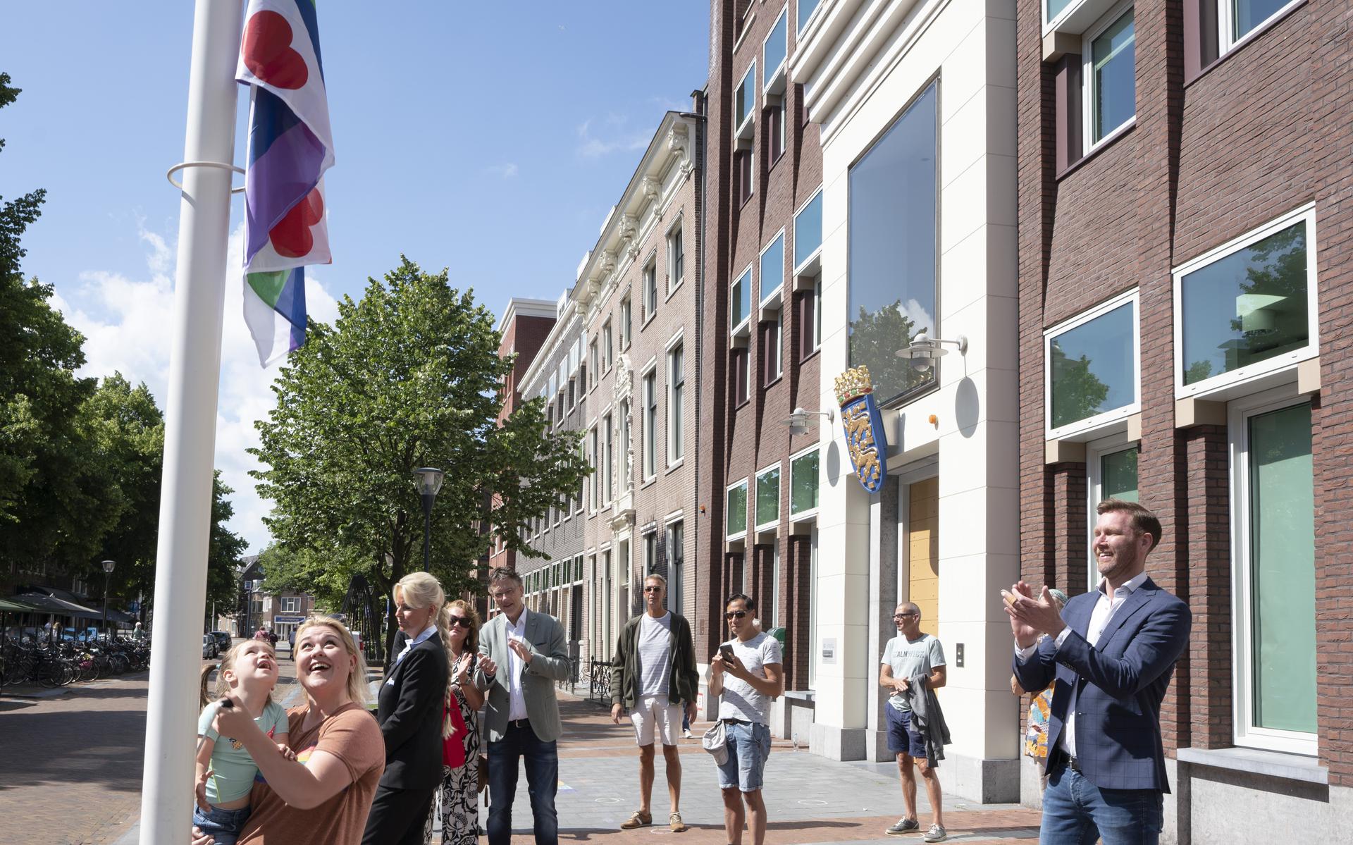 De Friese regenboogvlag worden gehesen voor het Provinsjehûs op de Leeuwarder Tweebaksmarkt. 