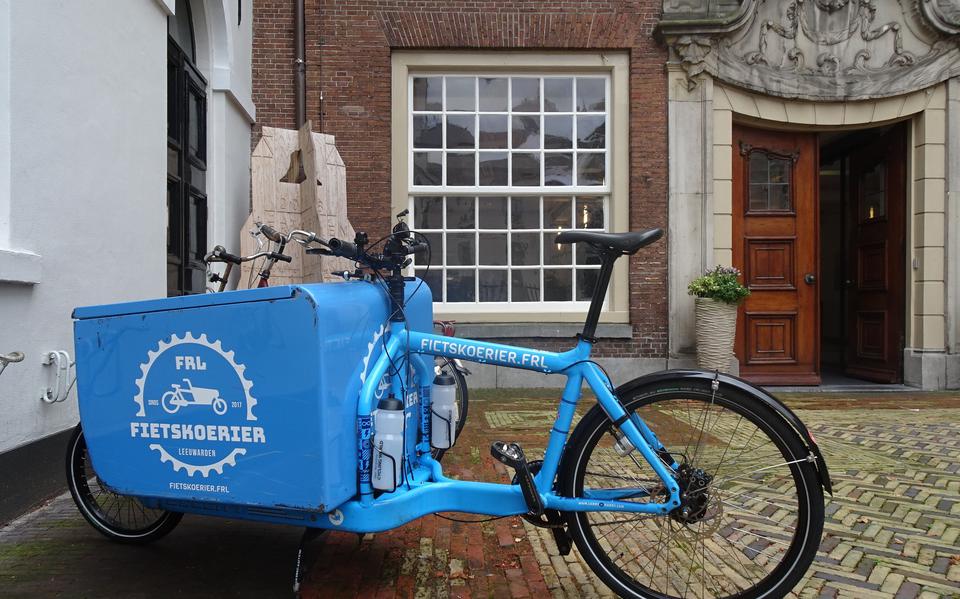 Een fiets van een fietskoerier voor het stadhuis in Leeuwarden.