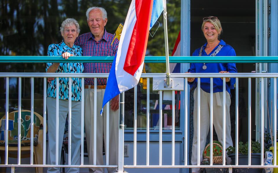 Het echtpaar Van der Molen-Oppenhuizen op hun balkon, met burgemeester Jannewietske de Vries op visite.