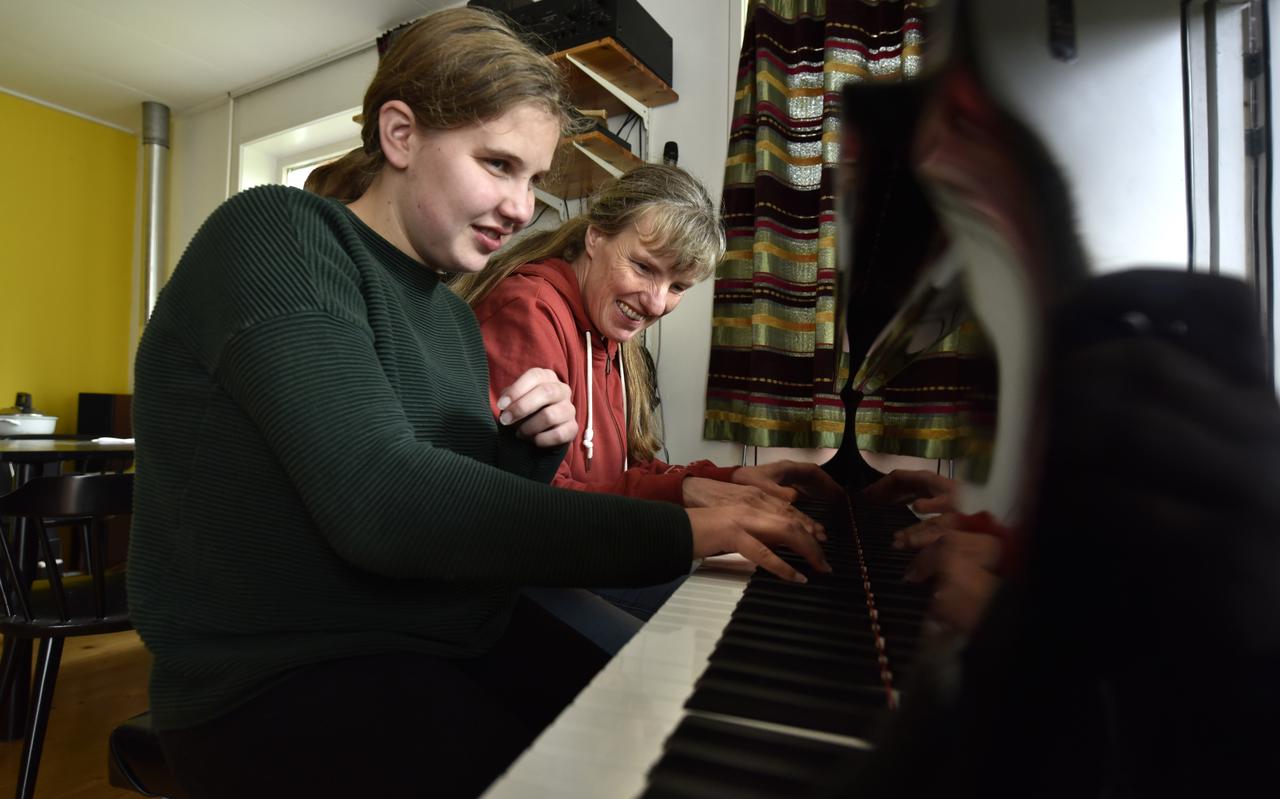 Met veel plezier zitten de blinde pianodocente Corinne Staal (r) en haar blinde leerling Fenna Dijkstra achter de piano