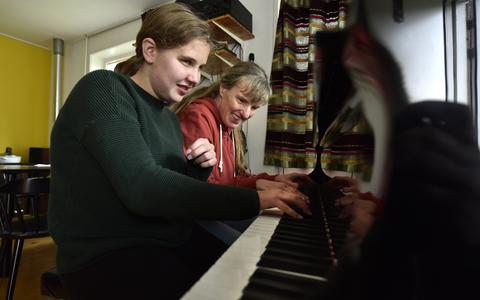 Met veel plezier zitten de blinde pianodocente Corinne Staal (r) en haar blinde leerling Fenna Dijkstra achter de piano