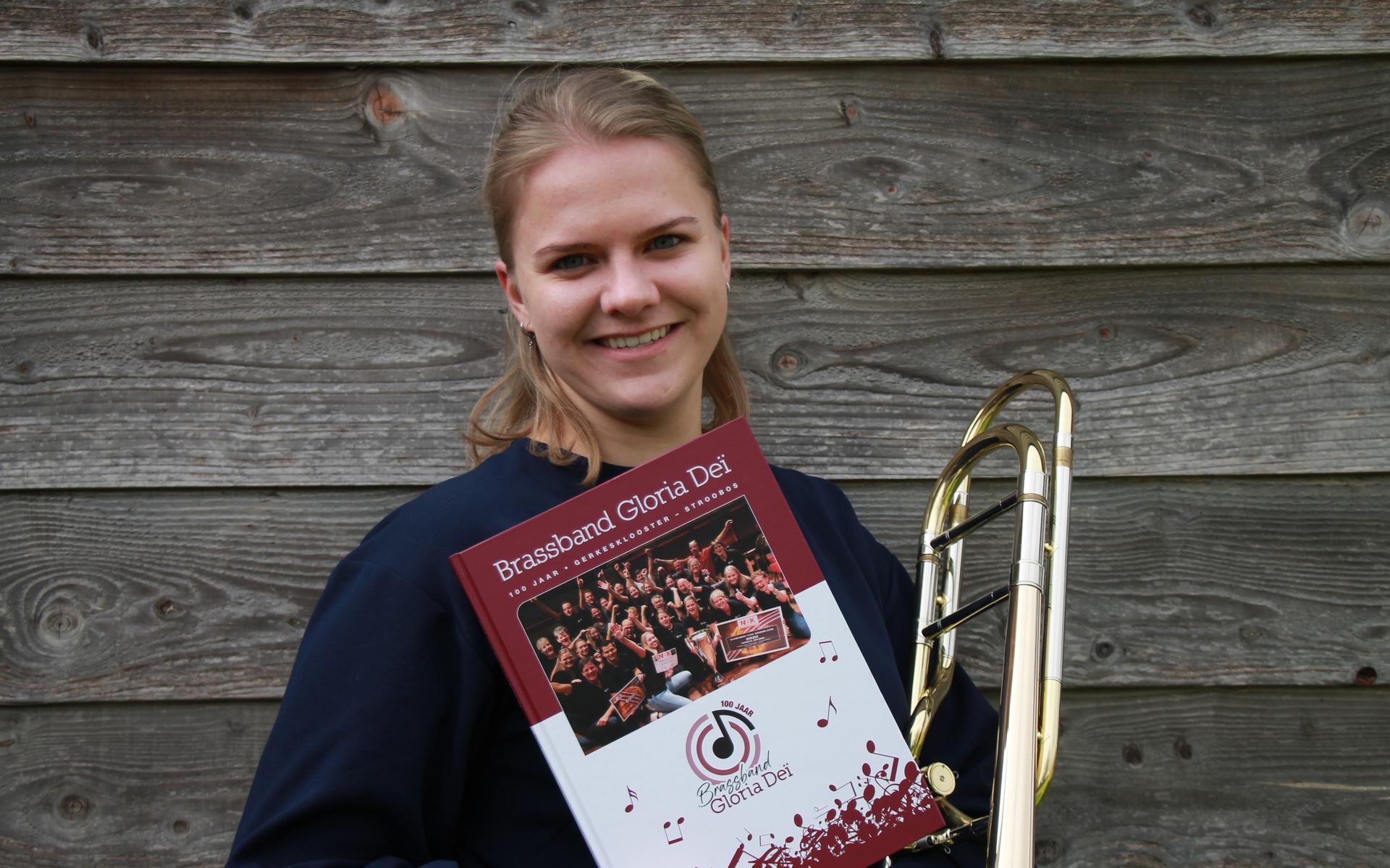 Jildou met het jubileumboek en haar trombone