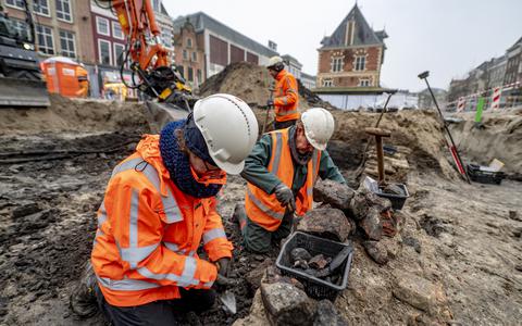 Famke Ansems (links) en Corrie van Hilten onderzoeken de muurresten van de oude Waag op het Waagplein in Leeuwarden. 