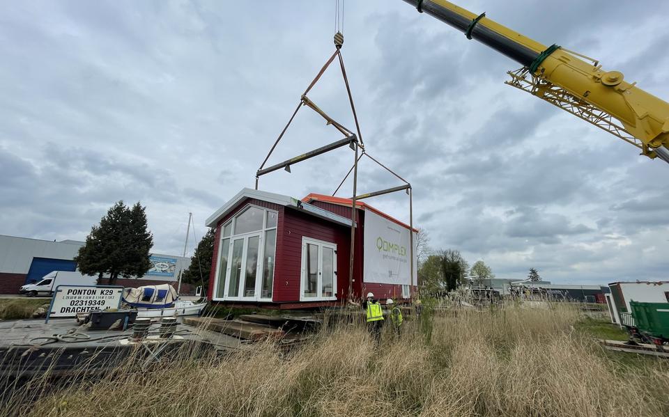 Het tiny house voor Terherne wordt bij de fabriek van Qomplex in Dokkum op een ponton getakeld.