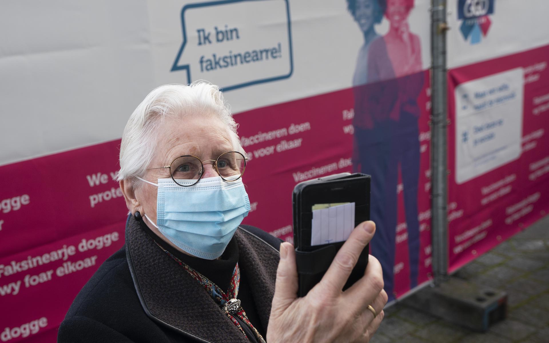 Trienke Bus (90) maakt een foto van zichzelf voor de selfiewand van GGD Fryslân, nadat ze is gevaccineerd tegen het coronavirus. 
